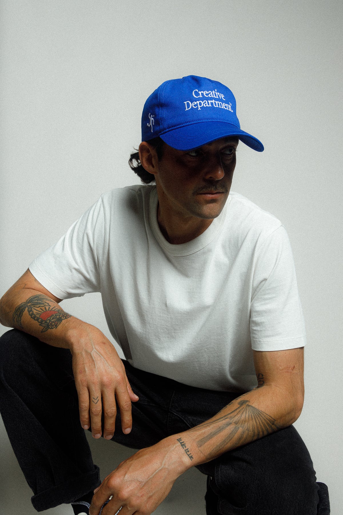 Model wearing the blue Creative Department snapback hat